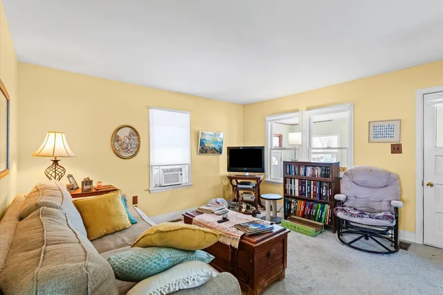 a living room with furniture a flat screen tv and a window