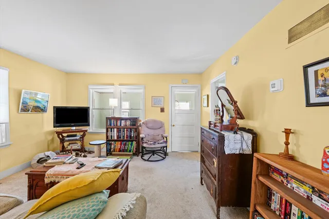 a living room with furniture a flat screen tv and a window