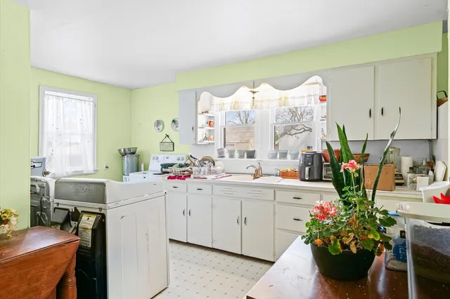 a view of a kitchen with kitchen island a sink dishwasher a stove with open dining table and chairs