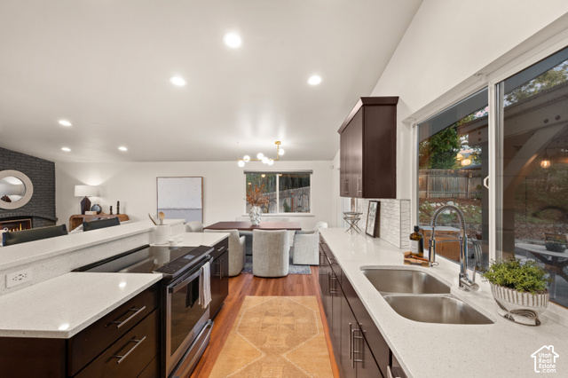 8678 Mount Majestic Road Sandy, UT 84093 - Photo 15 of 37 Chef's kitchen featuring dark wood cabinetry, stainless steel appliances, white quartz countertops, dual undermount sinks, and recessed lighting throughout