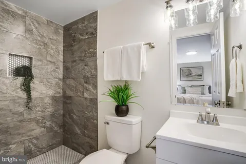 a bathroom with a sink a toilet and a mirror