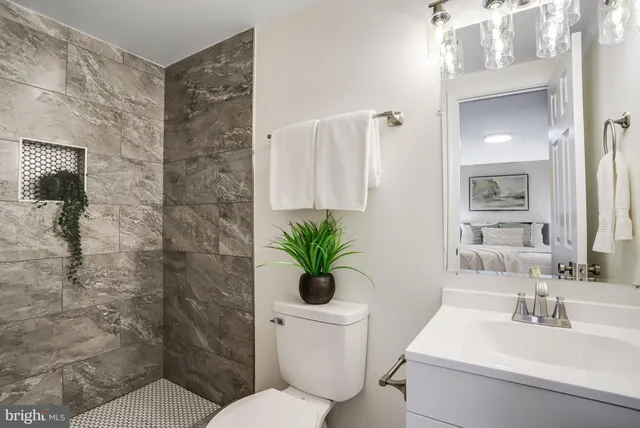 a bathroom with a sink a toilet and a mirror