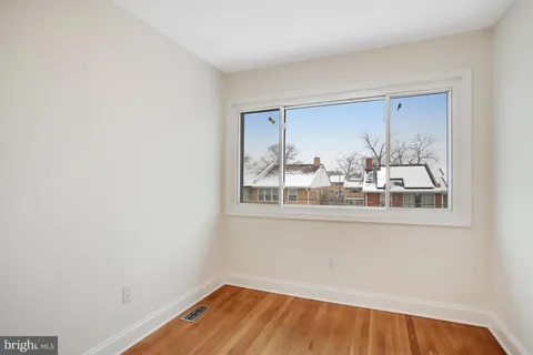 a view of a small space with wooden floor and a window