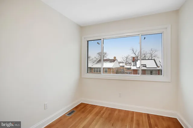 a view of a small space with wooden floor and a window