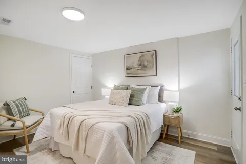 a bedroom with a bed and a painting on the wall