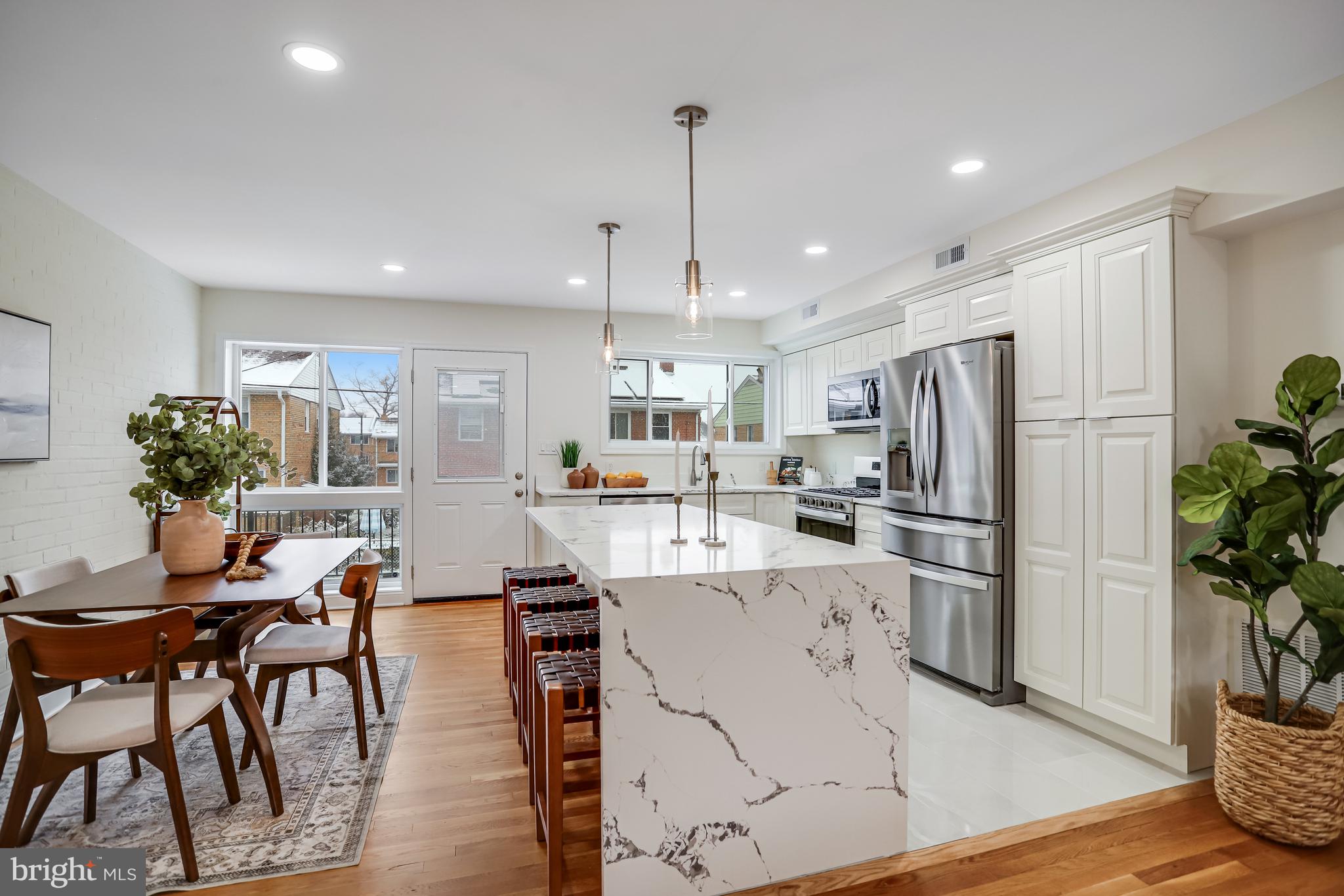 720 Decatur Street Northeast Washington, DC 20017 - Photo 5 of 26 a kitchen with stainless steel appliances kitchen island granite countertop a refrigerator and a dining table