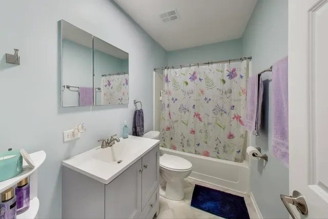 a bathroom with a sink a toilet and shower curtain