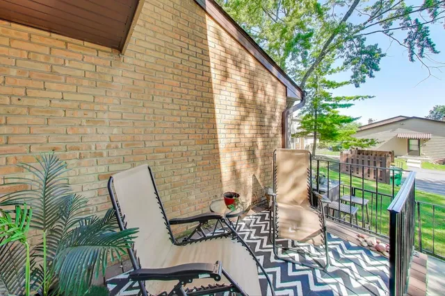 a balcony with chairs and potted plants