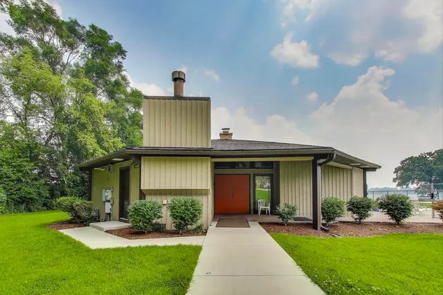 a front view of a house with a yard and potted plants