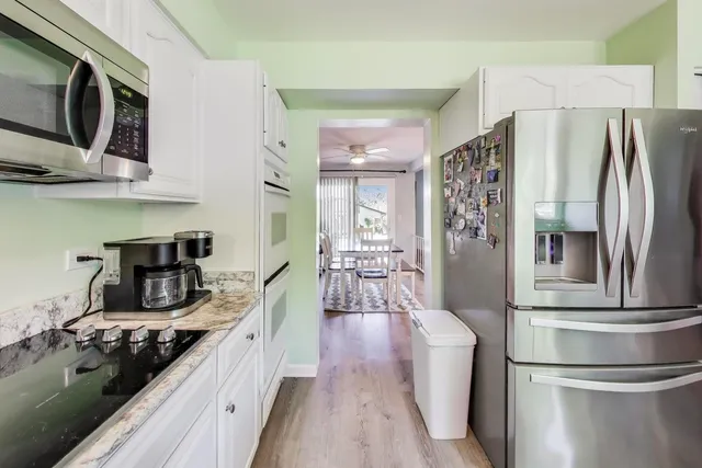 a kitchen with stainless steel appliances granite countertop a refrigerator stove and sink