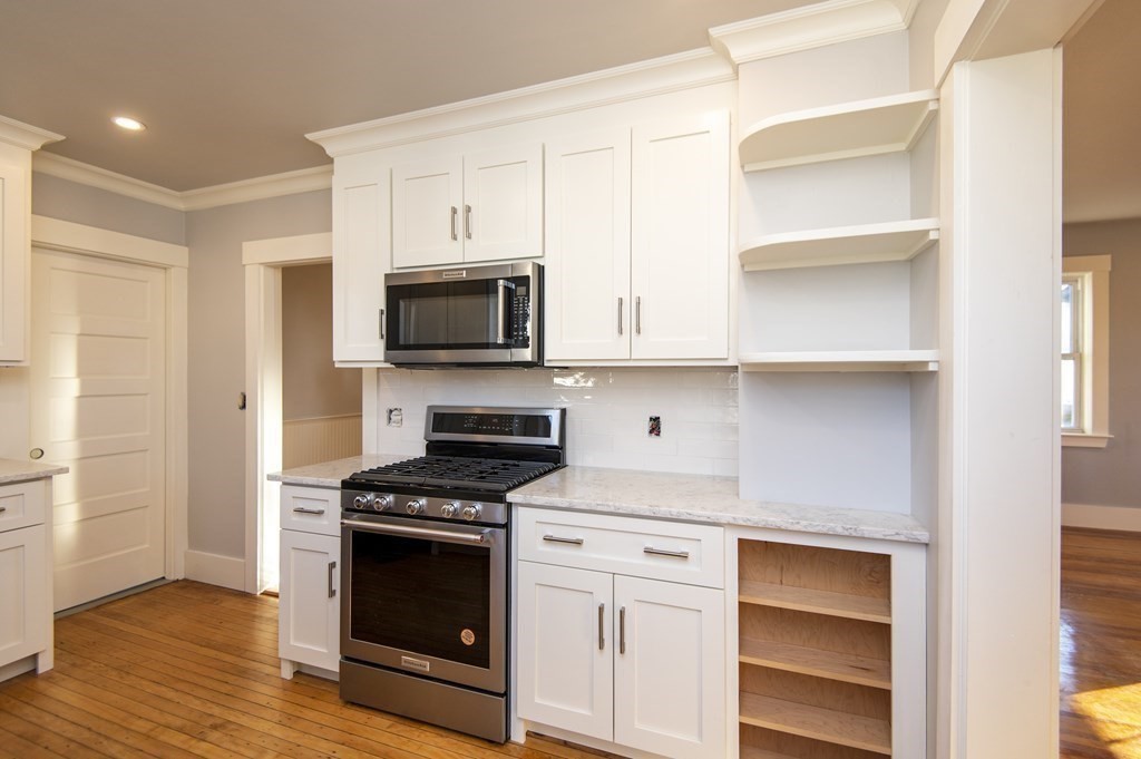 2 Burnside Street Maynard, MA 01754 - Photo 4 of 21 a kitchen with white cabinets and appliances