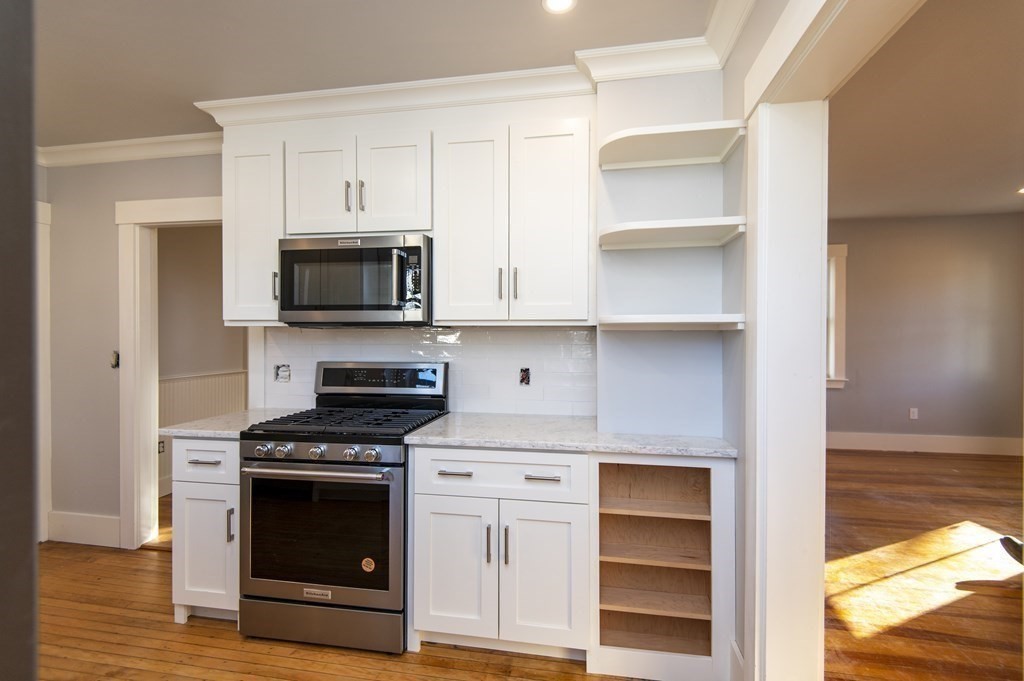 2 Burnside Street Maynard, MA 01754 - Photo 6 of 21 a kitchen with white cabinets and appliances