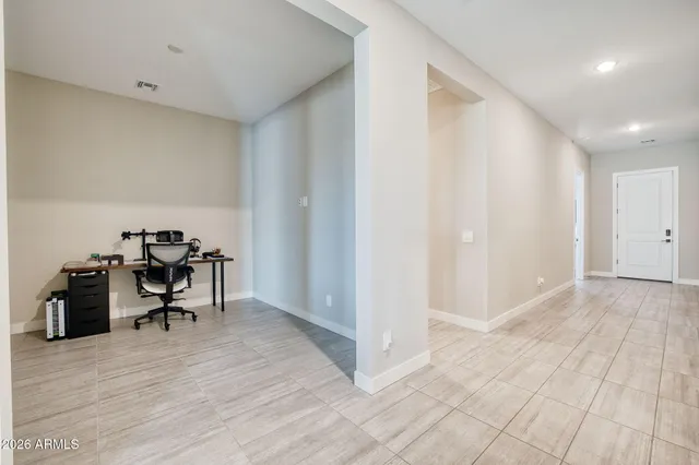 a view of a workspace with furniture and a window