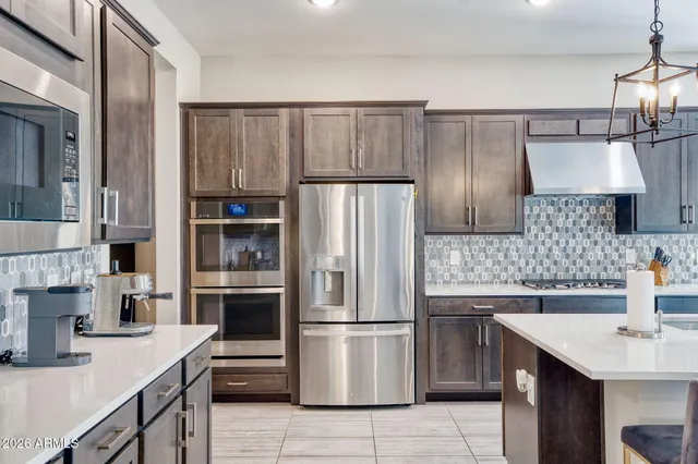 a kitchen with kitchen island a counter space a sink appliances and cabinets