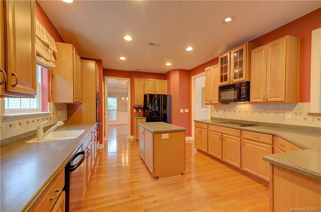 716 Beille Lane Fort Mill, SC 29708 - Photo 8 of 24 a kitchen with stainless steel appliances granite countertop wooden cabinets a sink dishwasher a stove and a refrigerator with wooden floor