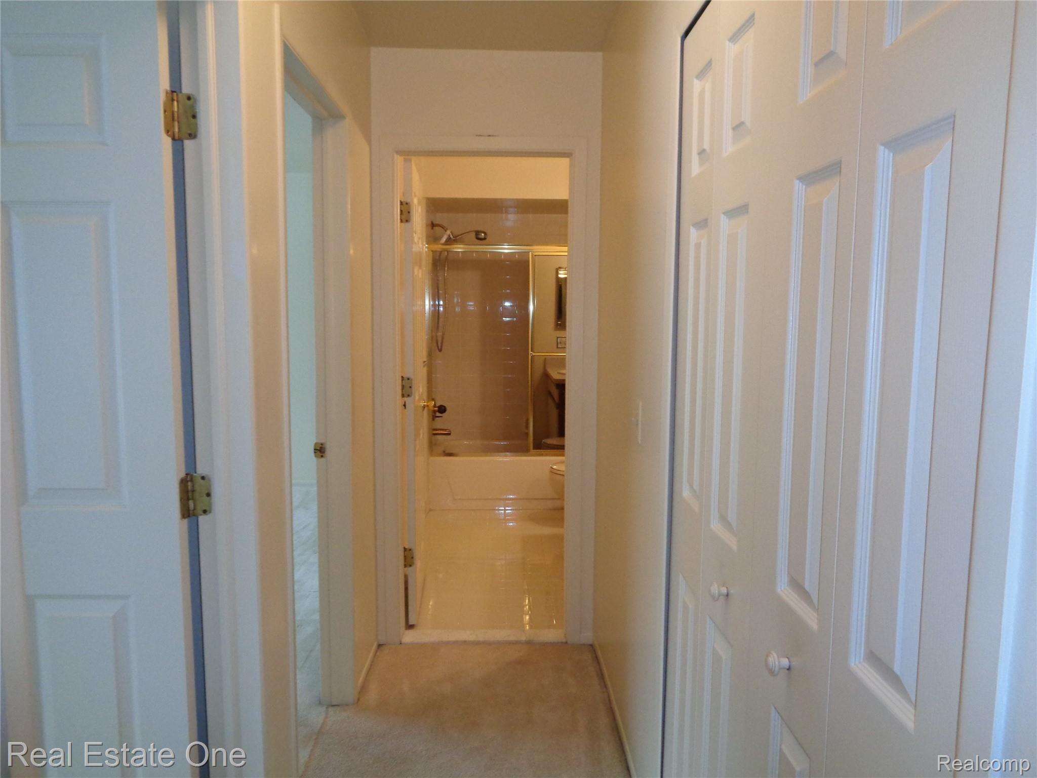 624 Tennyson, Unit 113 Rochester, MI 48307 - Photo 31 of 51 Hallway, from opposite view toward 2nd full bathroom, shiny clean!!! Also note the nice 6-paneled doors througout the home.