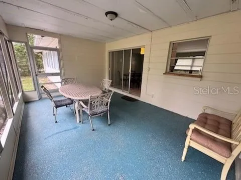 a view of a room with wooden floor fan and windows