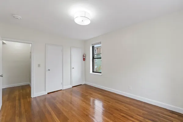 a view of an empty room with wooden floor