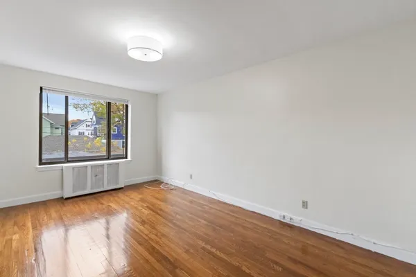 a view of room with wooden floor and white walls