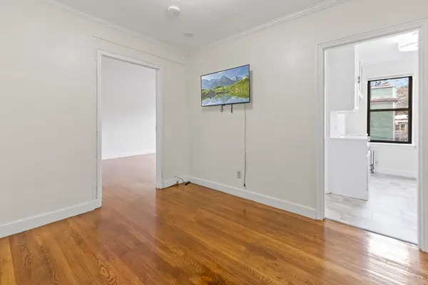 a view of an empty room with wooden floor