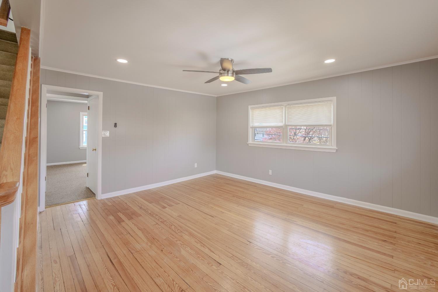 49 Riva Avenue, Unit 2 Milltown, NJ 08850 - Photo 11 of 22 an empty room with wooden floor ceiling fan and windows