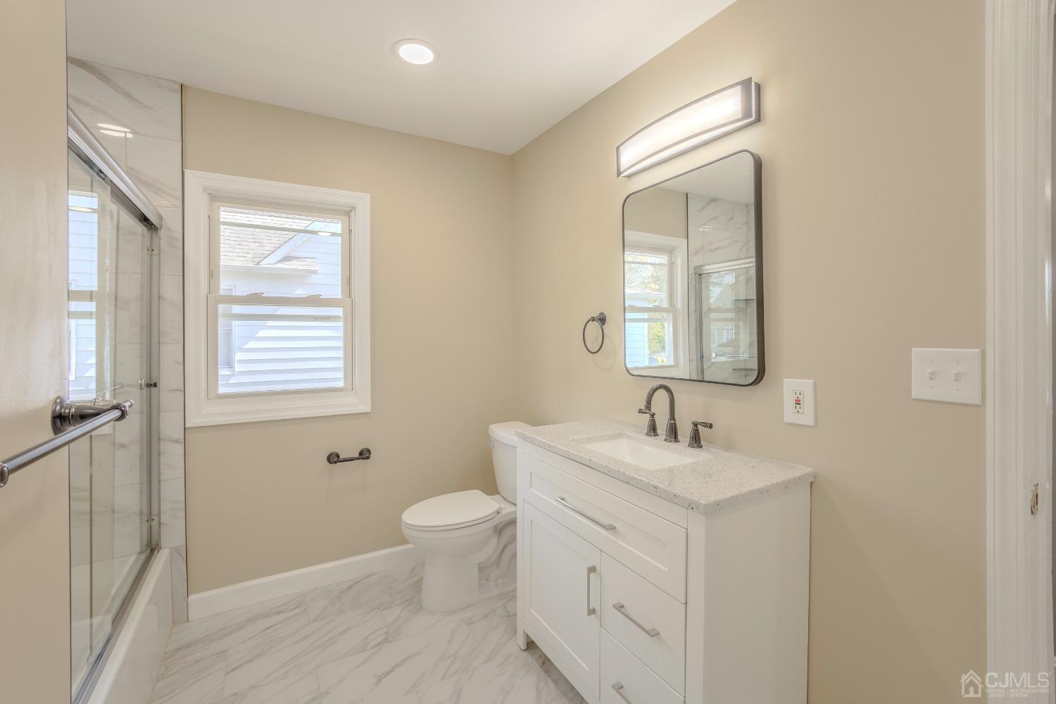 49 Riva Avenue, Unit 2 Milltown, NJ 08850 - Photo 7 of 22 a bathroom with a sink toilet and mirror