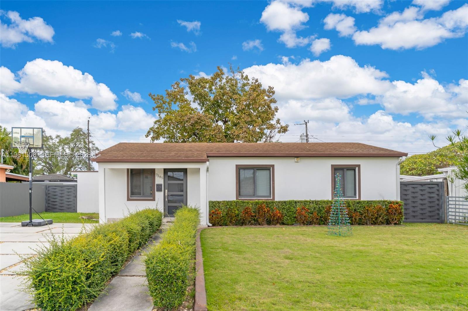 a front view of house with yard and trees in the background