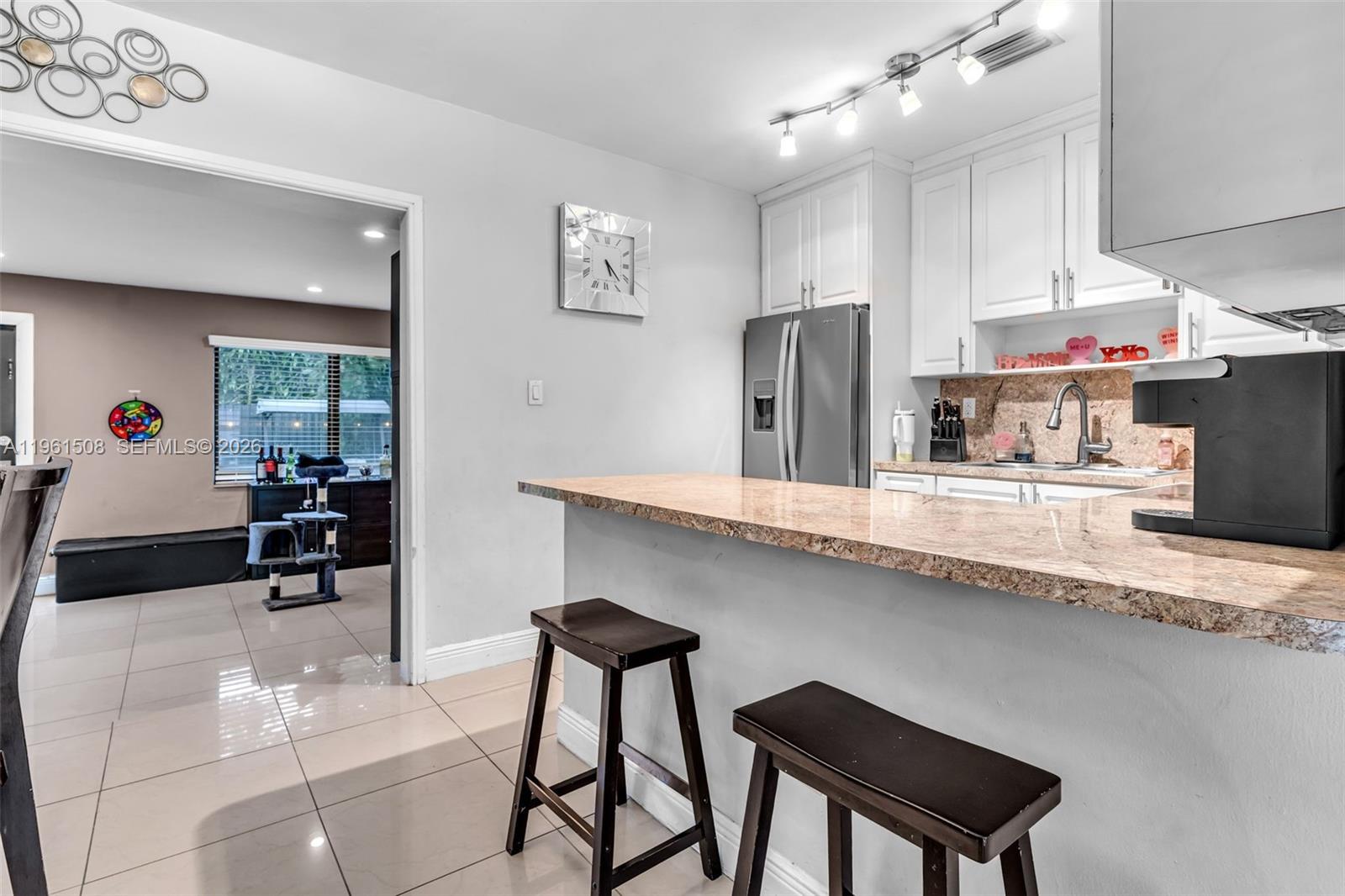 7585 Southwest 28th Street Miami, FL 33155 - Photo 11 of 28 a kitchen with stainless steel appliances granite countertop a sink counter space and cabinets