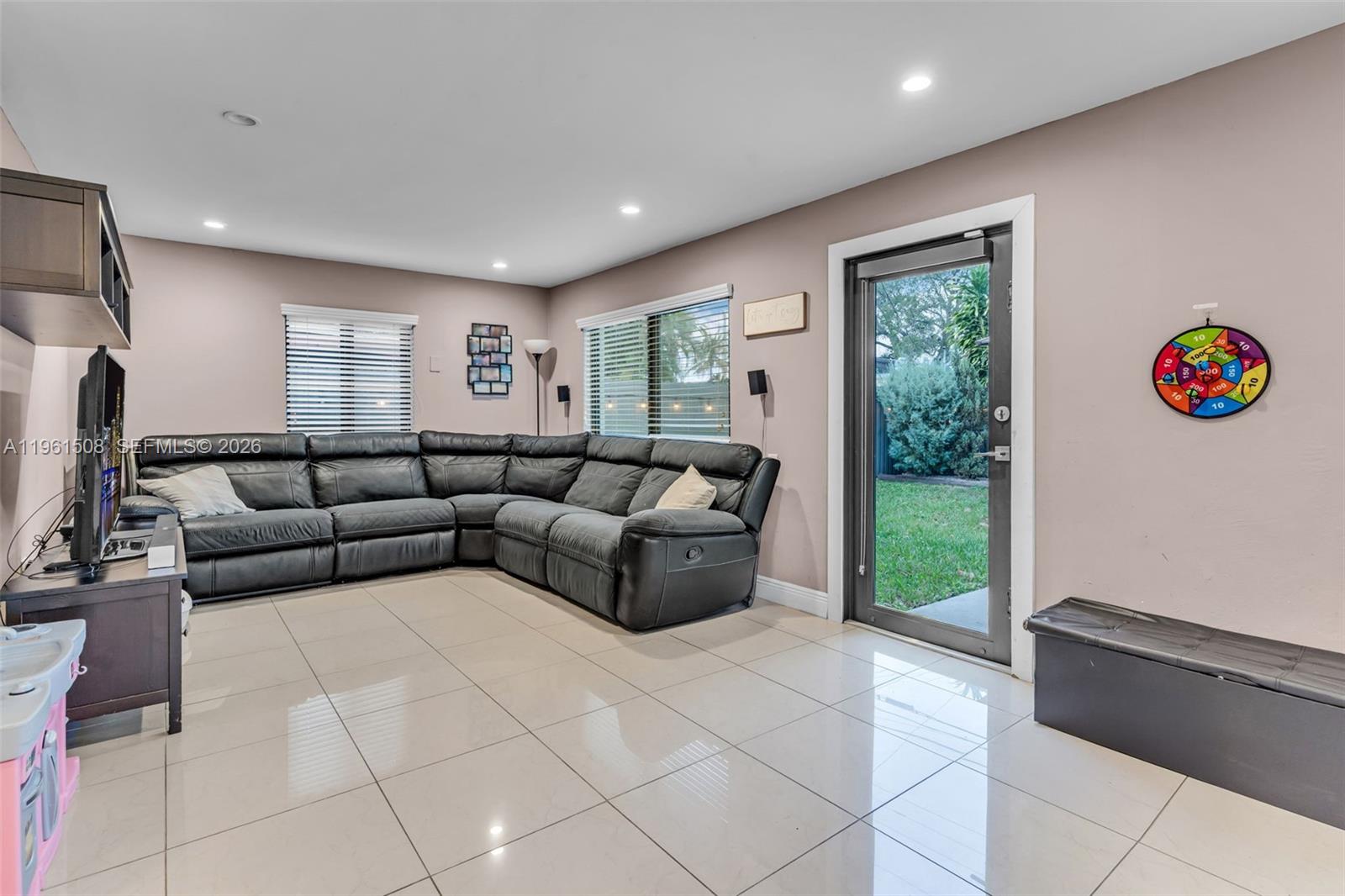 7585 Southwest 28th Street Miami, FL 33155 - Photo 12 of 28 a living room with furniture and a flat screen tv