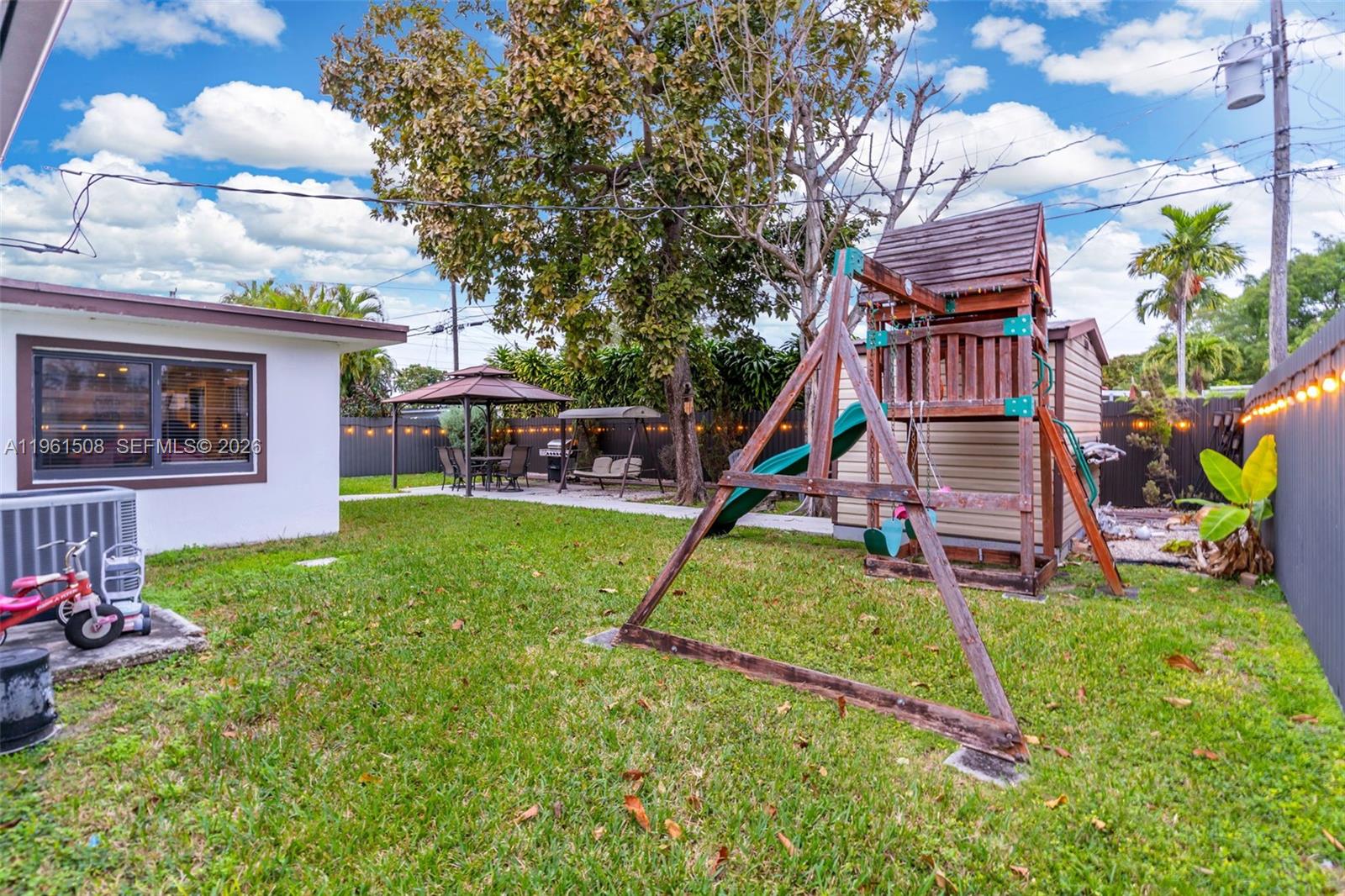7585 Southwest 28th Street Miami, FL 33155 - Photo 22 of 28 a view of a backyard with a slide and a tree