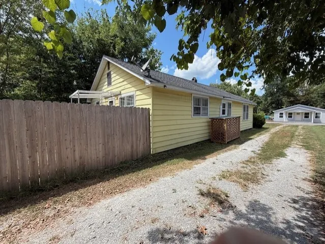 a kitchen with a refrigerator a stove a sink dishwasher with a dining table and chairs with wooden floor