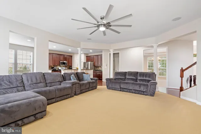 a kitchen with stainless steel appliances granite countertop a refrigerator a stove top oven and a sink with wooden floor