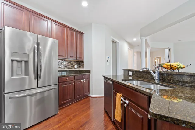 a dining room with wooden floor a chandelier a glass table and chairs