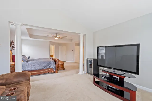 a living room with furniture a baby crib and a wooden floor