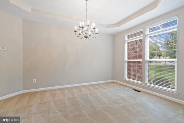 a view of a livingroom with a chandelier fan and windows