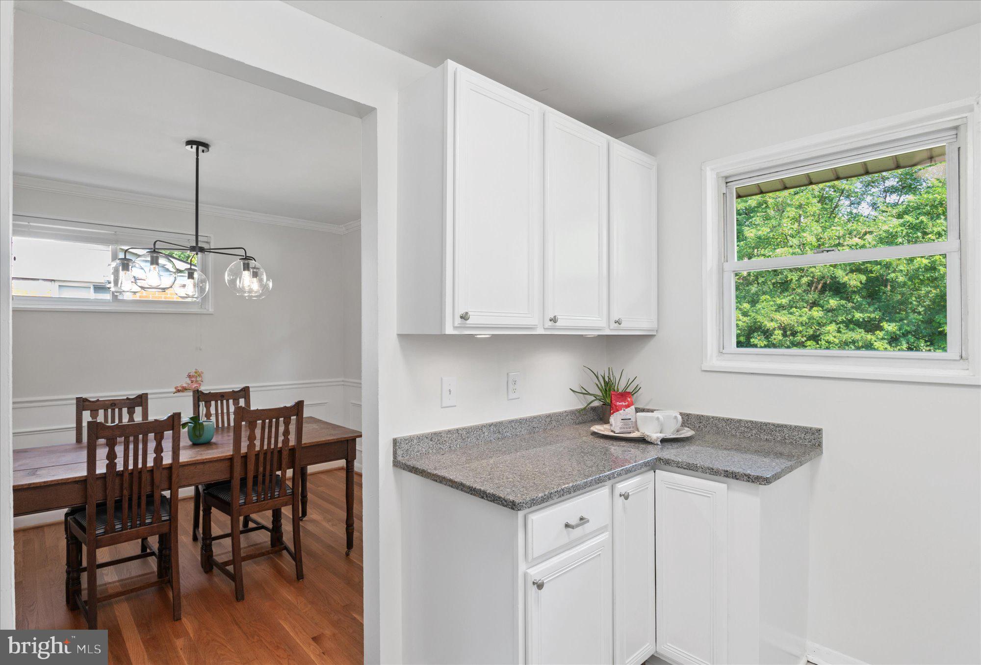 11201 Lombardy Road Silver Spring, MD 20901 - Photo 10 of 31 a kitchen with stainless steel appliances granite countertop a dining table chairs and a wooden floor