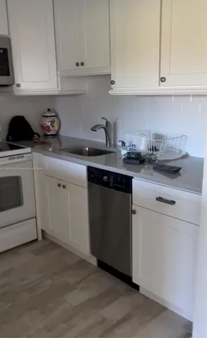 a kitchen with cabinets appliances a sink and a counter top