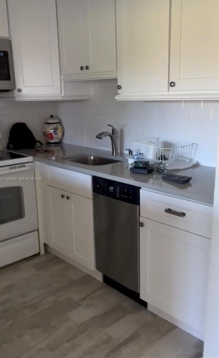 22 Brighton A, Unit 22 Boca Raton, FL 33434 - Photo 2 of 3 a kitchen with cabinets appliances a sink and a counter top
