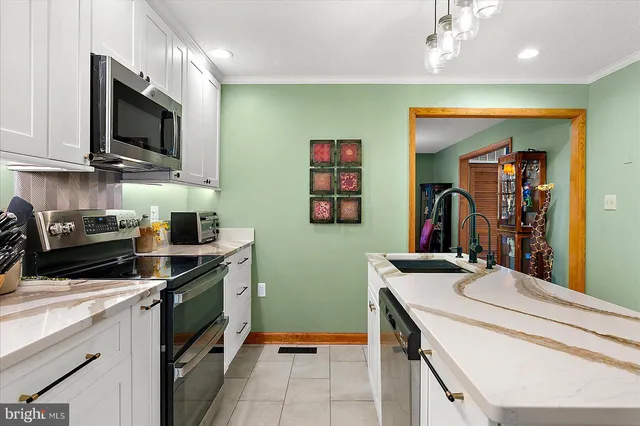 a living room with furniture kitchen view and a large window