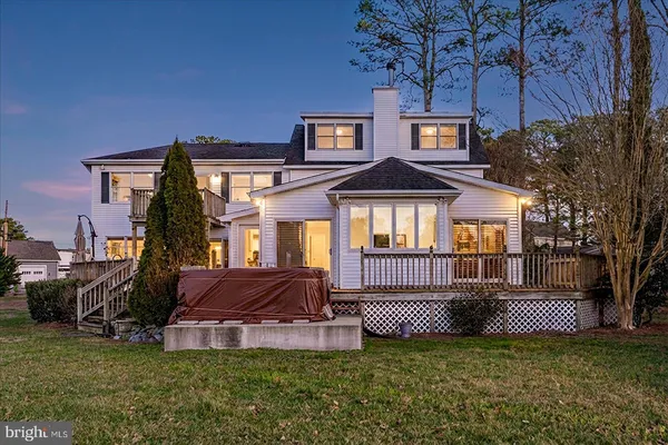 a view of a white house with a large windows and a table and chairs