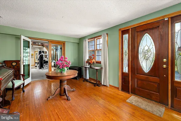 a living room with furniture a flat screen tv and a floor to ceiling window