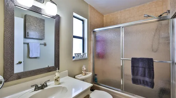 a bathroom with a shower sink and mirror