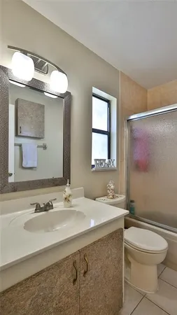 a bathroom with a sink a toilet and mirror