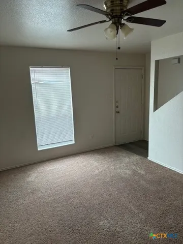 an empty room with a ceiling fan and closet area