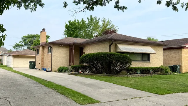 a front view of a house with a yard and potted plants