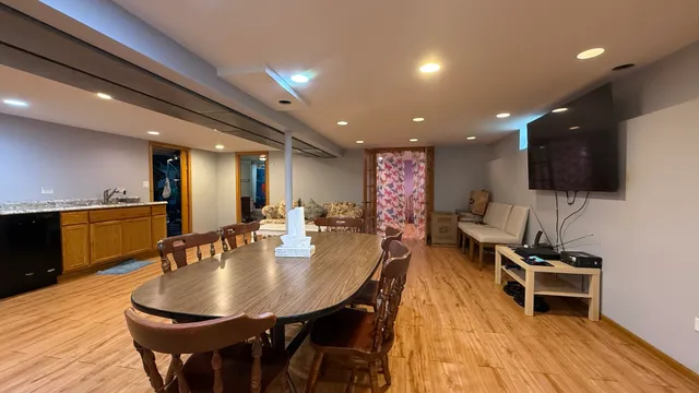 a kitchen with stainless steel appliances a dining table chairs stove and a sink