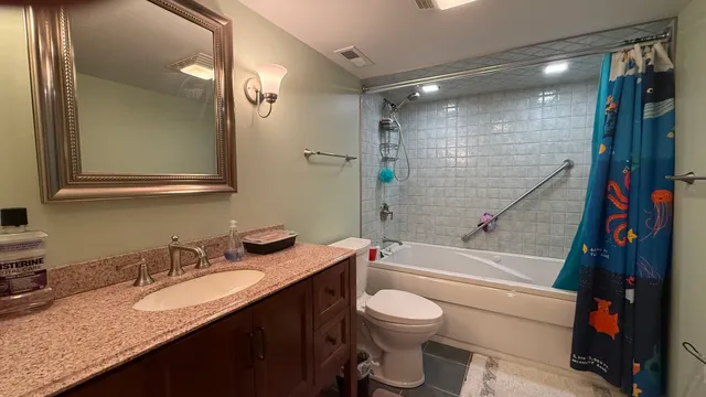 a bathroom with a granite countertop sink toilet and shower