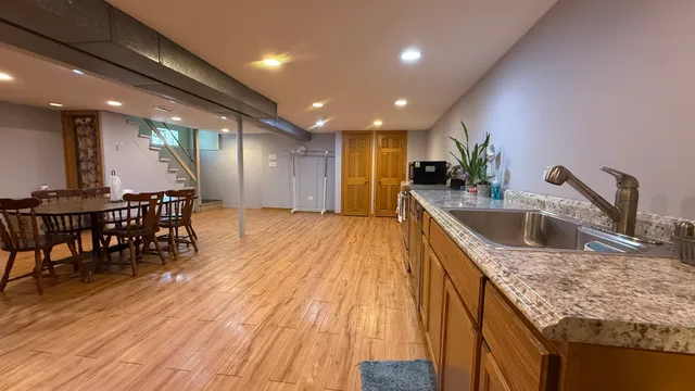 a kitchen with stainless steel appliances granite countertop a sink dishwasher and a stove with wooden floors