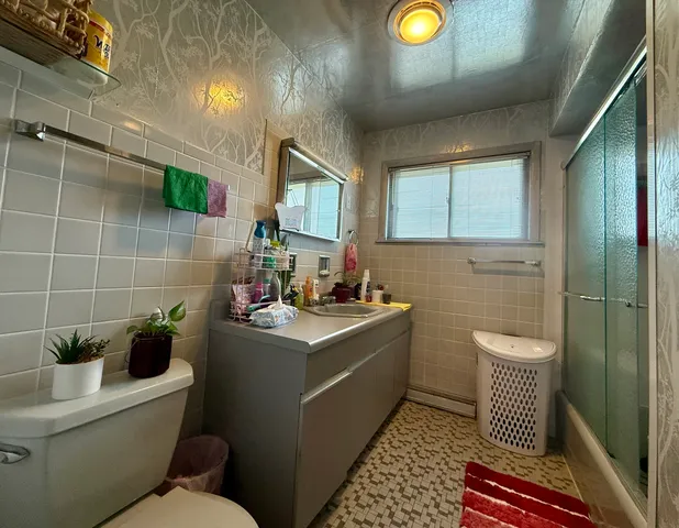 a bathroom with a toilet a sink and mirror