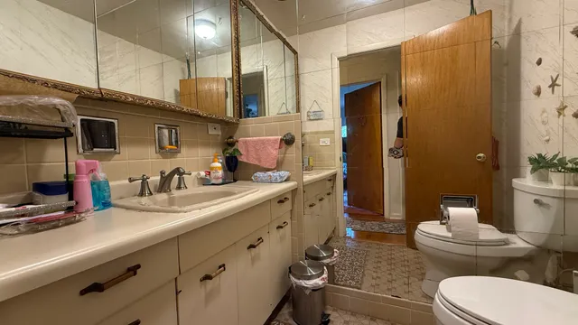 a bathroom with a granite countertop sink mirror and toilet